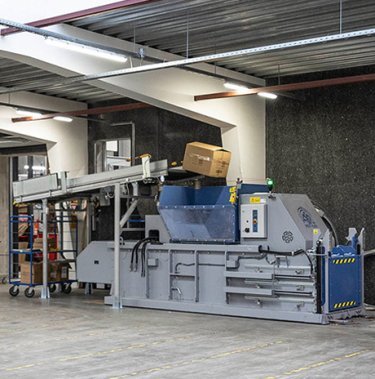 Presse à balles avec convoyeur pour le compactage automatisé des déchets carton