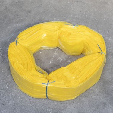 Cartouche de sacs en plastique jaunes Infinity format XL, liée avec du fil bleu, disposée en anneau sur une surface grise