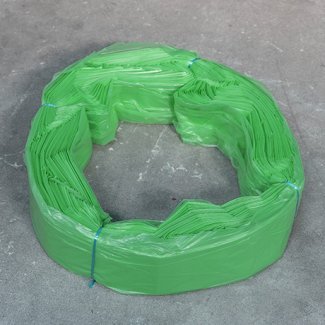 Cartouche de sacs en plastique verts Infinity format XL, liée avec du fil bleu, disposée en anneau sur une surface grise