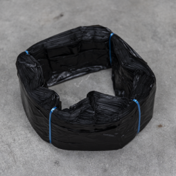 Cartouche de sacs en plastique noirs Infinity format standard, liée avec du fil bleu, disposée en anneau sur une surface grise