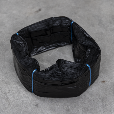 Cartouche de sacs en plastique noirs Infinity format standard, liée avec du fil bleu, disposée en anneau sur une surface grise