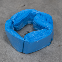 Cartouche de sacs en plastique bleus Infinity format standard, disposée en anneau sur une surface grise