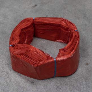 Cartouche de sacs en plastique rouges Infinity format standard, liée avec du fil bleu, disposée en anneau sur une surface grise